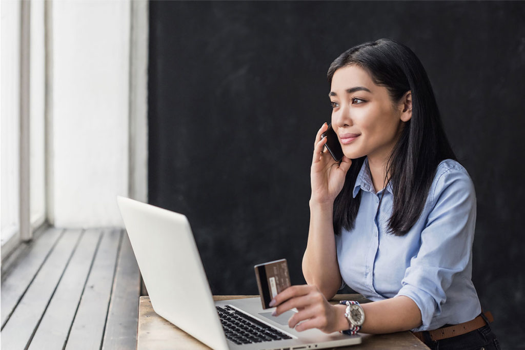 Woman talking on phone holding credit card