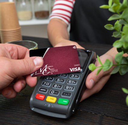 Image shows default debit card making purchase via contactless-enabled device