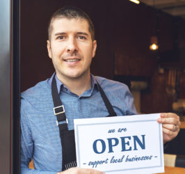 Business owner holding open sign