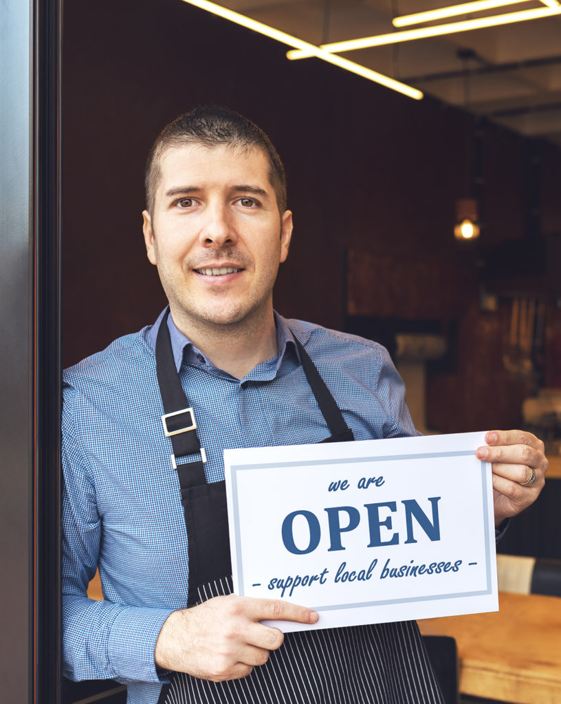 Business owner holding open sign