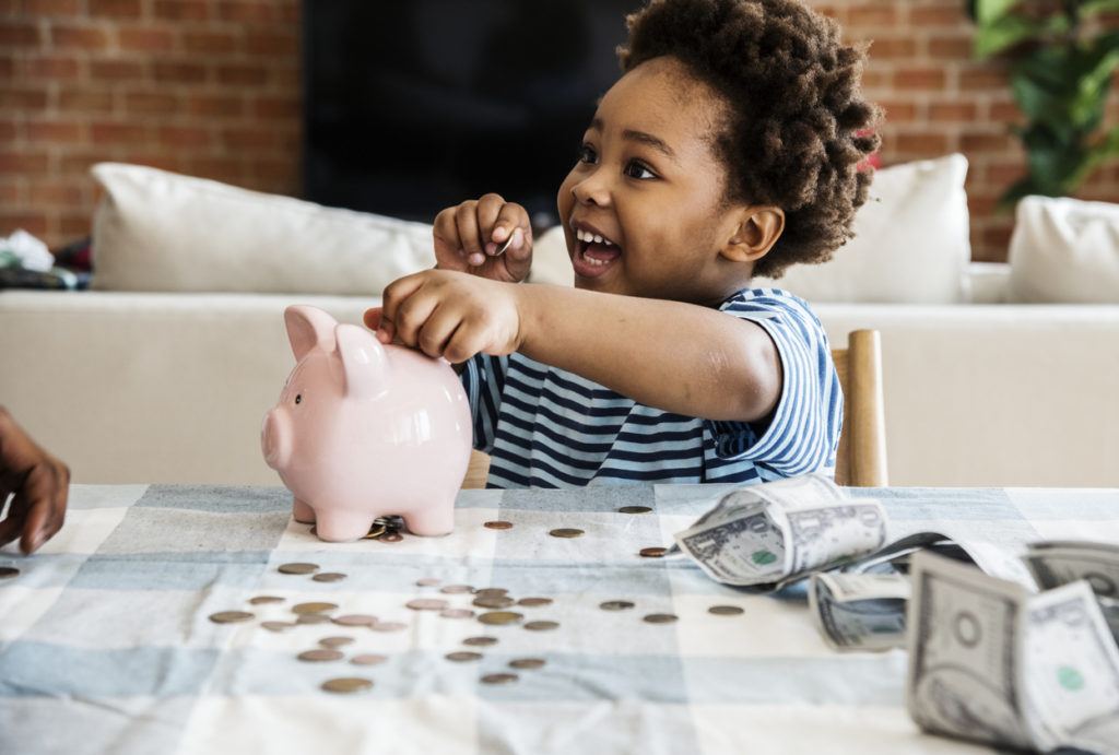 boy collecting money with piggy bank