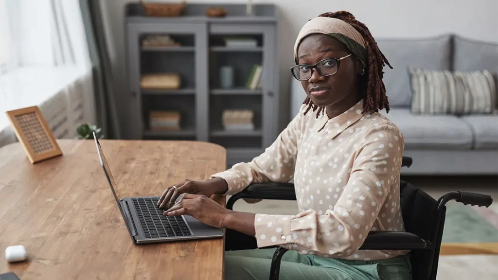 woman in wheel chair using laptop
